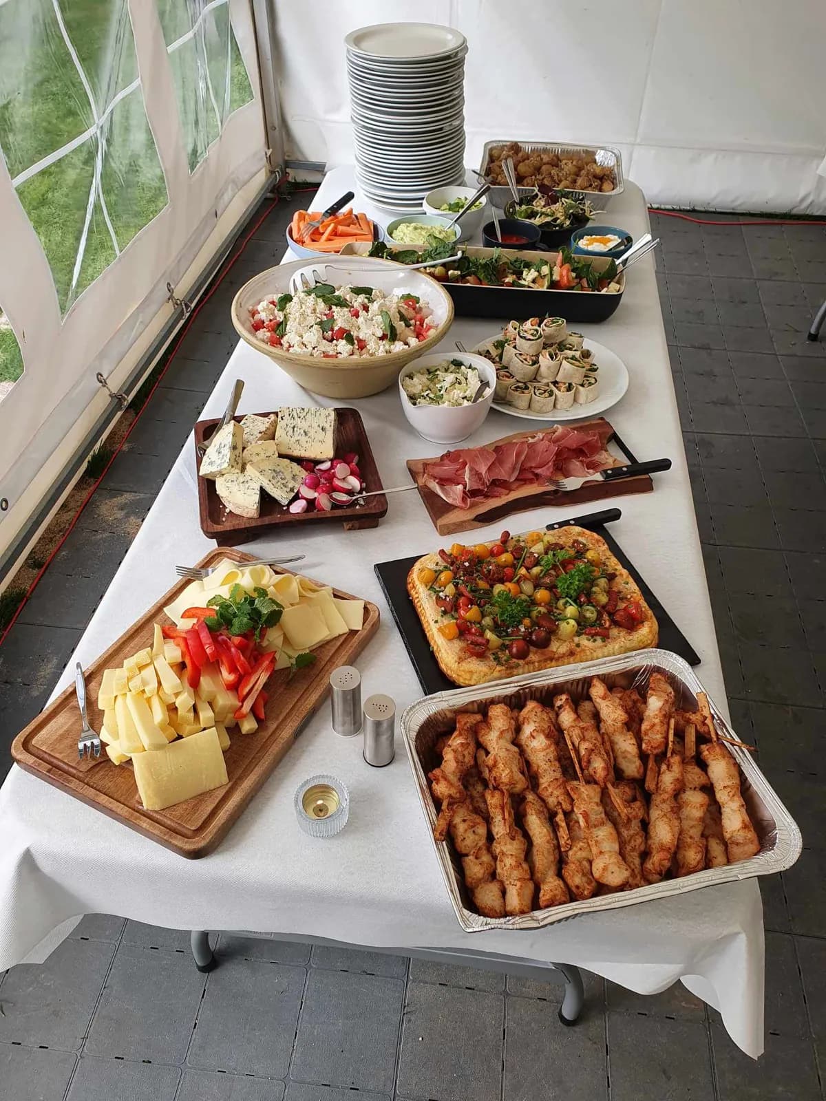 Tapasbord med små anretninger, pølser og oste på træfade